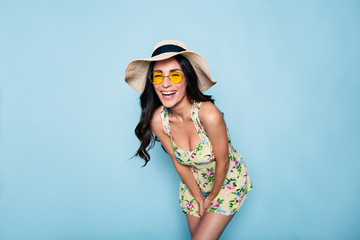 Portrait of cute summer brunette woman in hat, sunglasses and colorful dress, stylish girl have a...