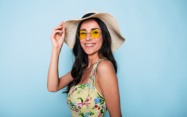 Portrait of cute summer brunette woman in hat, sunglasses and colorful dress, stylish girl have a...