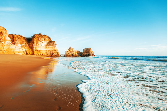 Fototapeta beautiful ocean landscape, the coast of Portugal, the Algarve, rocks on the sandy beach, a popular destination for travel in Europe