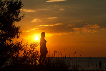 silhouette of a young woman on the beach at sunset