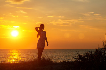 silhouette of a young woman on the beach at sunset