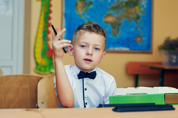 Pensive boy in class in elementary school . Initial training