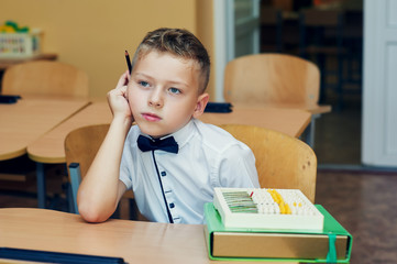 Pensive boy in class in elementary school . Initial training