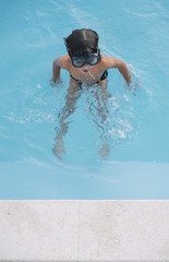 Kid playing and jumping in the pool