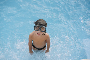 Kid playing and jumping in the pool