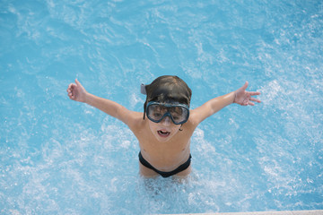 Kid playing and jumping in the pool