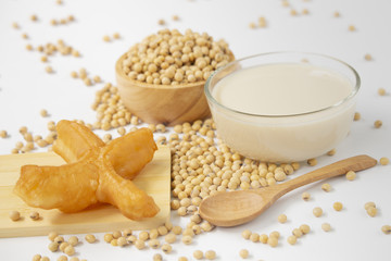 soy beans , soy milk  , wooden spoon  and Deep fried dough stick isolated on white background .
