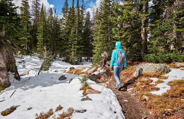Obraz premium Tourist with backpack hiking on snowy trail