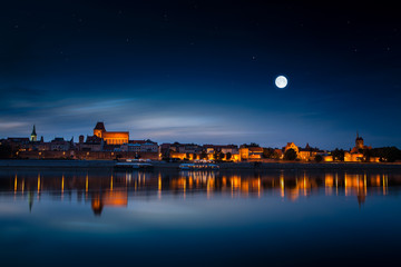 Old town reflected in river at sunset. Torun, Poland