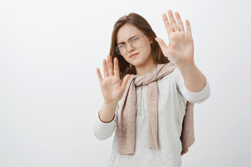 Step back you bother me. Displeased intense cute woman in glasses with short brown hair bending...