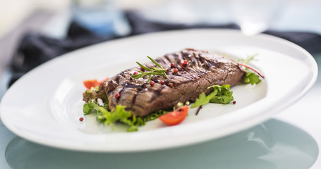 Close-up  juicy flank steak from vegetable salad.