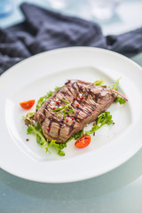 Close-up  juicy flank steak from vegetable salad.