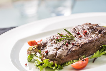 Close-up  juicy flank steak from vegetable salad.