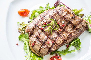 Close-up  juicy flank steak from vegetable salad.