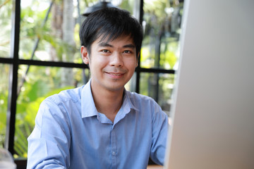 asian businessman smiling and looking to camera merge with big data in the laptop