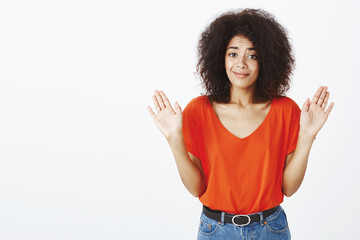 Do not blame me. Portrait of unaware beautiful african-american girl with afro haircut, smirking at...