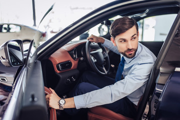 businessman closing the driver's door of the car
