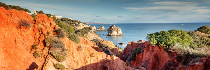 Panorama of Praia da Marinha on the south coast of Portugal in the Algarve on a sunny day. The cliffs, beach and Atlantic ocean are in view with tourists on the beach