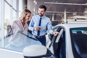 client and salesman looking at new car