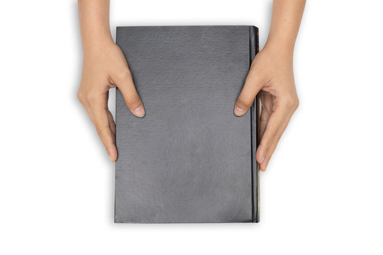 Hands Holding Closed Book With Black Blank Cover On White Background