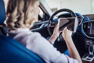 woman in the car using digital tablet