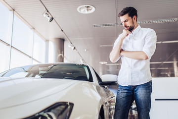 male client looking at car in dealership salon