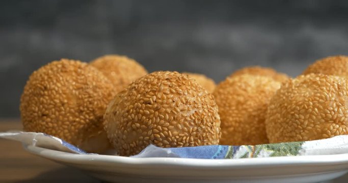 Woman picks up a traditional asian style glutinous rice ball to eat, from a plate, 4K