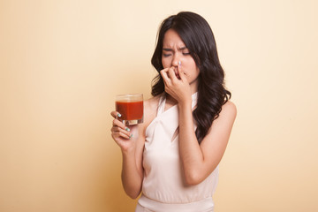 Young Asian woman hate tomato juice.