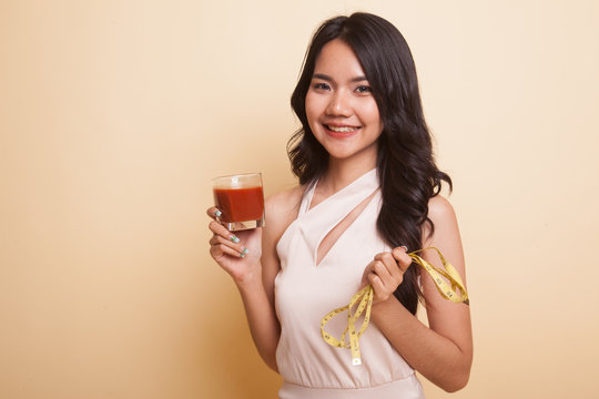 Asian woman with tomato juice and measuring tape.