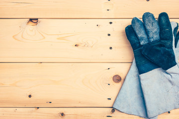 leather work gloves on wooden plank