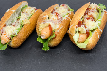 delicious homemade hot dogs on black slate close up photo