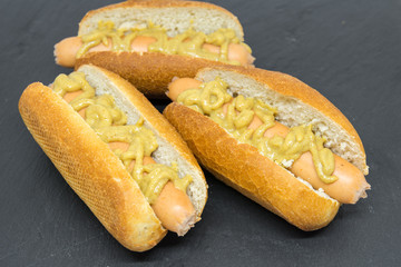 delicious homemade hot dogs on black slate close up photo