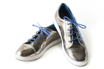 Girls' silvery shiny glamorous shoes with blue laces on a white background