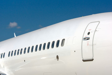 windows and entrance door at modern white passenger airplane