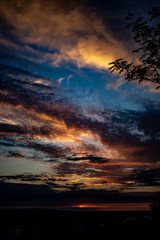 Fototapeta premium Vibrant clouds lit up by the setting sun.