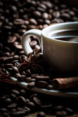 Coffee cup and beans on a rustic background. Coffee Espresso and a piece of cake with a curl. Cup of Coffee and coffee beans on table.