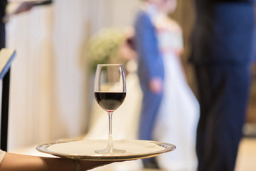 Waiter is carring plate with red Wine glasses. glasses. Wine glasses. Waitress holding a dish of champagne and wine glasses at festive event, party or wedding reception