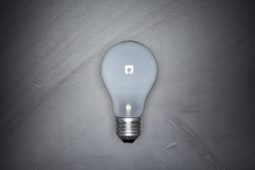 Light bulb on black blackboard background