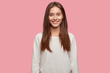 Isolated shot of pleasant looking cheerful brunette youngster has appealing look, healthy skin,...