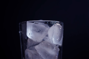 a glass of blur plain white ice cubes in black background