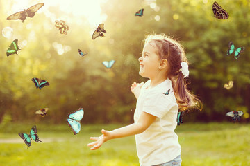 Laughing cute child with a butterfly on his hands. Fairy dreams for princess girl. Happy childhood...