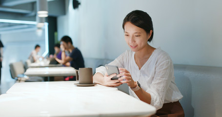 Woman use of smart phone in coffee shop