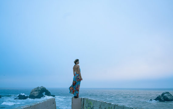 woman in dress in front of ocean