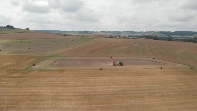 Lone tractor making hay in vast French landscape. Aerial footage.