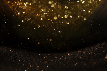 glitter vintage lights background. black and gold. de-focused.