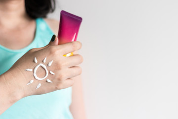 Holding Sunscreen bottle with cream as sun shape on hand, woman skincare for summer vacation