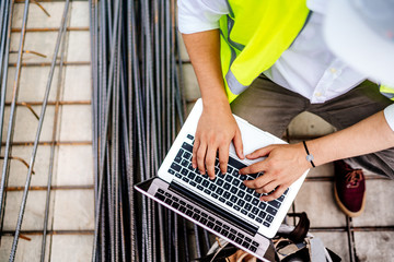 close up details of engineer working on laptop on construction site