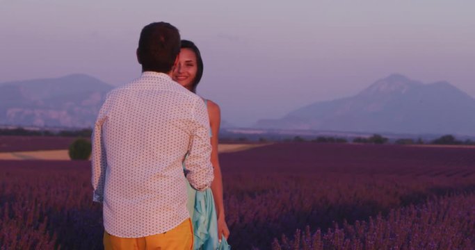 romantic couple in lavender purple flower field taking photos with smart phone