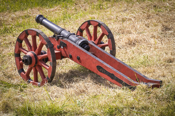 Acting real antique cannon on wooden wheels in the field