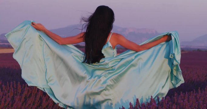 lavander flower field woman in cyand dress having fun and relax on wind in  purple flower field